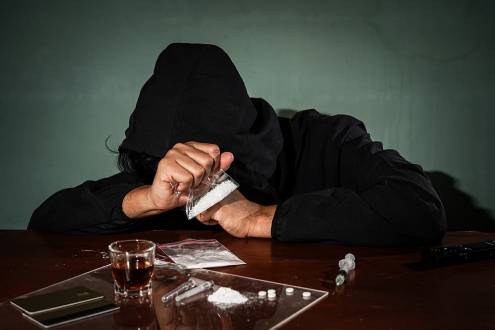 Man hand holds plastic packet drugs or bag with cocaine, drug abuse and danger addiction